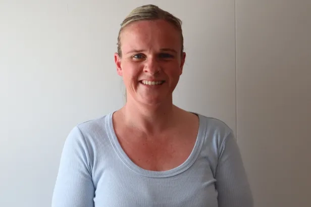 Middle aged woman in business casual smiling.
