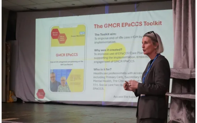 Speaker at digital skills event gives talk as a PowerPoint slide in the background reads 