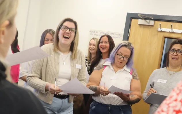 Care leaders look on smiling during a group discussion.