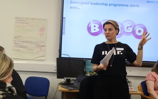 Head trainer on the LEAD Programme gestures to participants at the front of the classroom as they look on